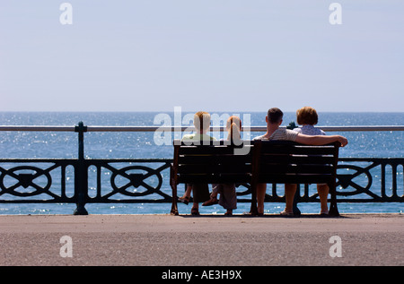 Une famille s'asseoir ensemble sur le front de mer de Brighton sur un bel après-midi d'été. Photo par Jim Holden. Banque D'Images