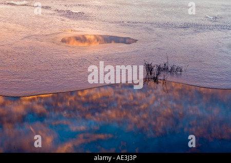 Ciel du matin reflète dans l'eau et de la glace de lac partiellement gelé, le Grand Sudbury, Ontario, Canada Banque D'Images