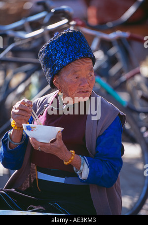 Femme ayant le petit déjeuner nouilles dans la province du Yunnan Dali marché Chine Banque D'Images