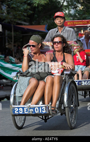 Deux femmes tour vieux quartier de Hanoi en cyclo-pousse Vietnam Banque D'Images