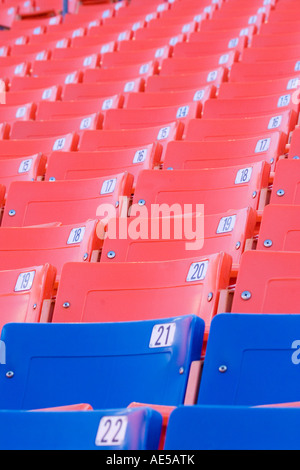 Rangées de bleu et rouge vide sièges numérotés à un stade Banque D'Images