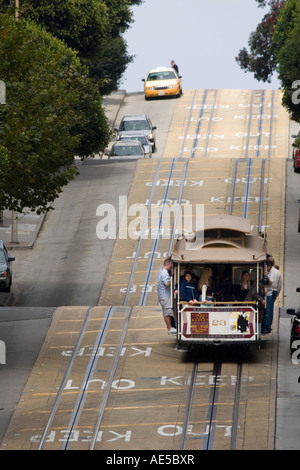 Cable car rempli de touristes en vacances qui navigue le long d'une section raide de Powell Street à San Francisco, Californie Banque D'Images