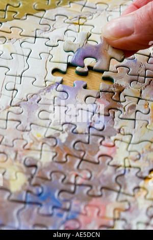 Jigsaw Puzzle pieces connectés ensemble avec mise en main la dernière pièce manquante Banque D'Images