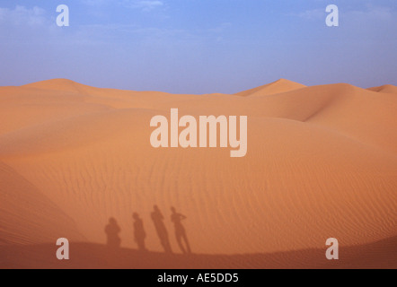 Les touristes de grimper une dune de sable dans le désert du Sahara Maroc Banque D'Images