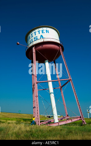 Femme caucasienne posant avec humour comme si elle tenait le château d'eau incliné à Britten, Texas, USA. Banque D'Images