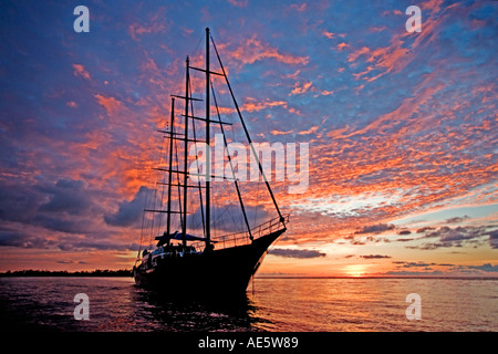 Location silhouetted against sunset Sea Star Yacht à intellectuelle a annoncé aux Seychelles Banque D'Images
