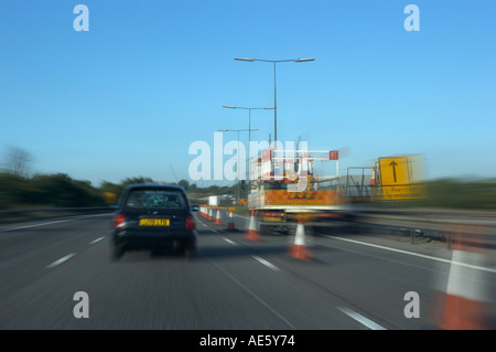 Une voiture PASSE À TRAVERS LES TRAVAUX ROUTIERS AUTOROUTE Banque D'Images