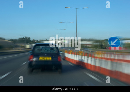 Une voiture PASSE À TRAVERS LES TRAVAUX ROUTIERS AUTOROUTE Banque D'Images