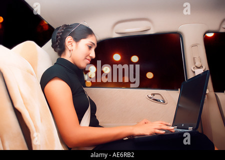 RHS70947 jeunes Indiens de l'Asie du sud de la dame dans une voiture Honda travaillant sur ordinateur portable modèle libération Nombre 522 Banque D'Images