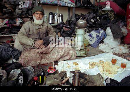 Un cordonnier prend le thé du matin dans le Grand Bazar d'Ispahan Bozorg, Iran Banque D'Images