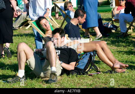 La lecture de l'homme et la femme les personnes qui dorment au soleil relaxant à Hay Festival 2006 Hay-on-Wye Powys Pays de Galles UK GO Banque D'Images