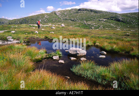 La randonnée Ecosse Galloway Hills hill walker walking passé lochan sur le côté de colline Snibe UK Banque D'Images