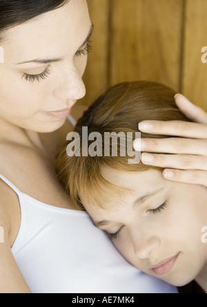 Preteen girl resting head on la poitrine de jeune femme Banque D'Images