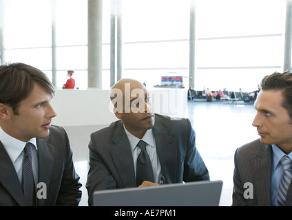 Trois hommes d'parler in airport Banque D'Images