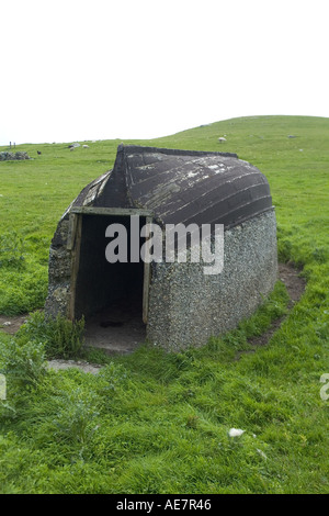 dh Banna Minn WEST BURRA SHETLAND Fishermans hangar avec le vieux bateau utilisé comme toit de recyclage de toiture Banque D'Images