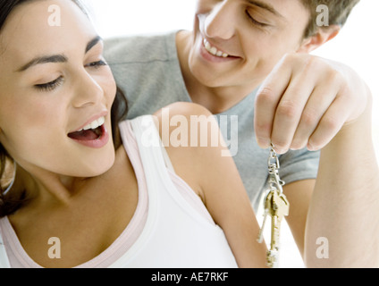 Man holding up clés, femme surpris Banque D'Images