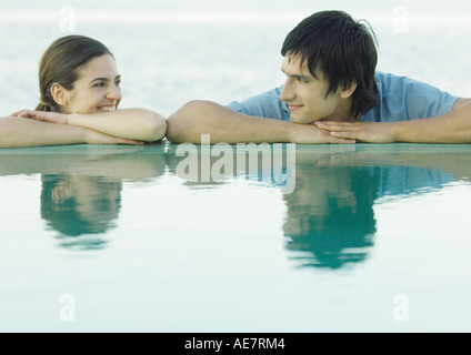 Young couple smiling at each other par l'eau Banque D'Images