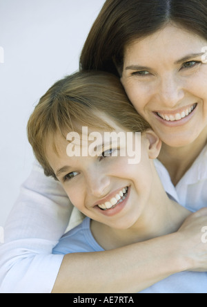 Mère wilth bras autour des épaules de sa fille, tous deux à l'écart et smiling, portrait, close-up Banque D'Images