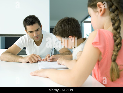 Père d'aider les enfants à faire leurs devoirs Banque D'Images