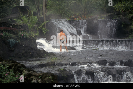 Un touriste prend un bain dans un ruisseau de la forêt tropicale à Tabacon Hot Springs près du Volcan Arenal, Costa Rica. Banque D'Images