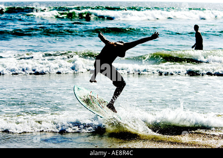 Boarder écrémé est découpé sur le rivage d'Hunnington Beach, CA USA. Banque D'Images