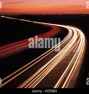 Coucher du soleil au-delà des sentiers de véhicule léger sur trois voies à deux voies sur l'autoroute A12 Trunk road dans l'Essex, Angleterre Royaume-uni crépuscule soir Rush hour Banque D'Images