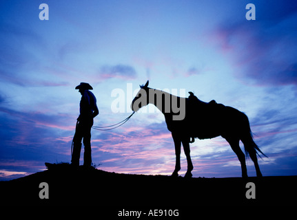 Portrait d'un cow-boy et son cheval au coucher du soleil sur un grand ranch de bétail près de Post dans l'ouest du Texas Banque D'Images