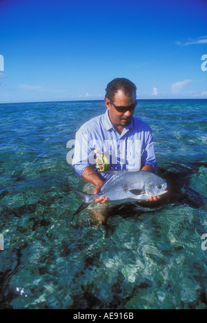 Man holding permettre poissons capturés lors de la pêche à la mouche dans le sud du Belize Caraïbes parution modèle droit Banque D'Images