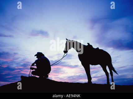 Portrait d'un cow-boy et son cheval au coucher du soleil sur un grand ranch de bétail près de Post dans l'ouest du Texas Banque D'Images