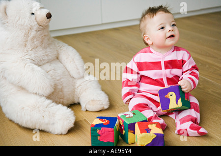 Bébé jouant, sitting on floor Banque D'Images
