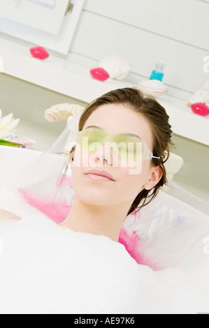 Jeune femme ayant une baignoire, avec un masque de gel Banque D'Images
