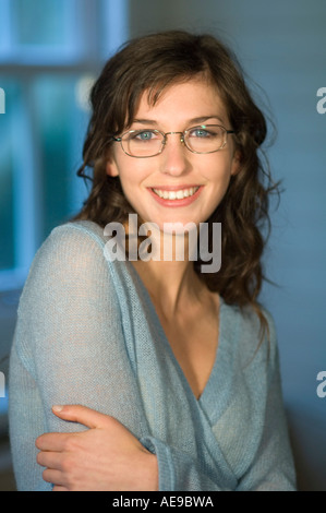 Portrait d'une jeune femme avec des lunettes, smiling for the camera Banque D'Images