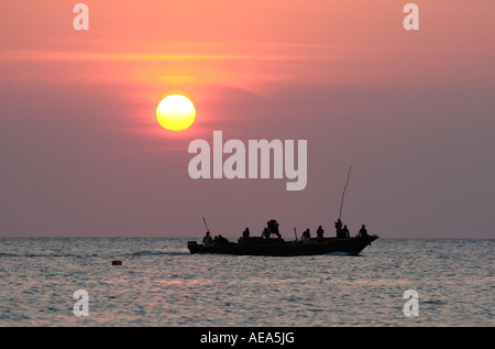 Tanzanie Zanzibar sur les gens de dhow croisière au coucher du soleil vu de la plage de Kendwa Rocks Banque D'Images