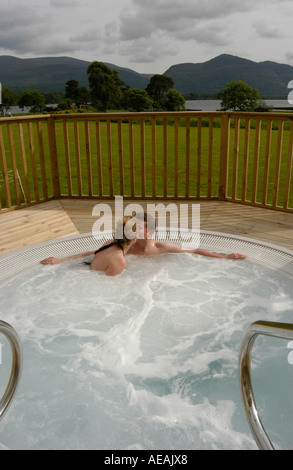 Un jeune homme et de la femme dans une baignoire jacuzzi à l'extérieur de Killarney, Irlande Banque D'Images