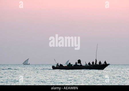 Tanzanie Zanzibar sur les gens de dhow croisière au coucher du soleil vu de la plage de Kendwa Rocks Banque D'Images