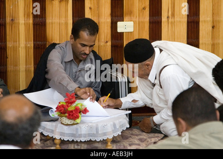 Tripoli (Libye). Célébrations de mariage musulman. L'oncle du marié signe un contrat de mariage au nom de famille. Banque D'Images