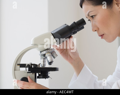 Asian female scientist à microscope en Banque D'Images