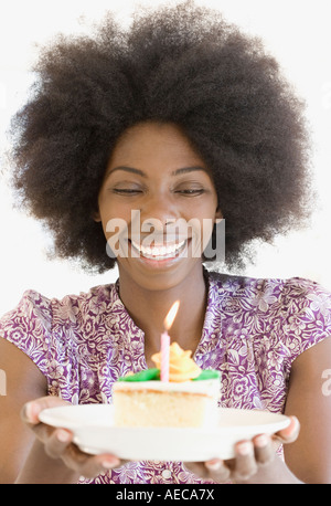 African woman holding piece of cake Banque D'Images