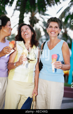 Les femmes hispaniques eating ice cream cones Banque D'Images
