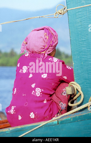 Femme Cham assis dans un bateau de pêche sur la rivière Sanke, Kampot, Cambodge Banque D'Images
