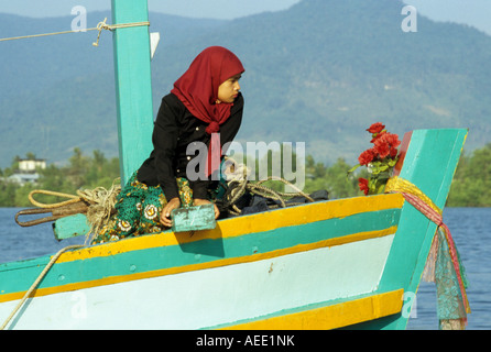 Cham femme assise dans la proue du bateau de pêche sur la rivière Sanke, Kampot, Cambodge Banque D'Images