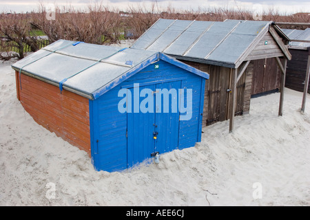 Cabane de plage à moitié enfoui dans une dune de sable dans la région de West Wittering Banque D'Images