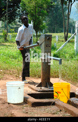 Une jeune femme noire africaine en pompant de l'eau à l'Afrique de l'Est Kenya École Maseno Banque D'Images