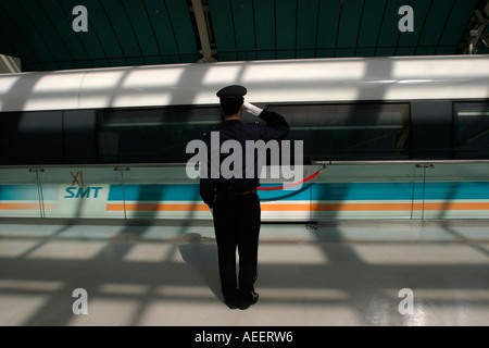 Un garde salue le train à sustentation magnétique Maglev qui transporte les passagers de Longyang Lu gare à l'aéroport de Pudong Banque D'Images