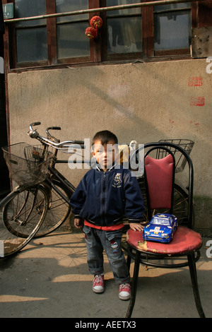 Shanghai Chine un jeune garçon devant son domicile, à l'arrière-rues de ville chinoise dans la partie ancienne de Shanghai Banque D'Images