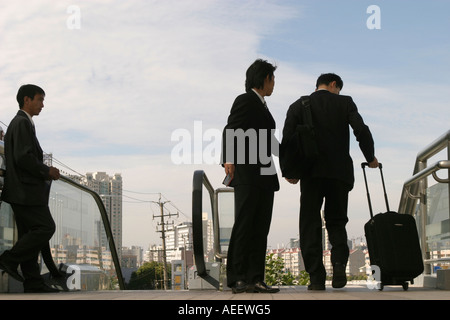 Un jeune homme donne les cartes d'agent de voyages pour les piétons sur une passerelle à côté de la station de métro Longyang Lu, Shanghai Chine Banque D'Images