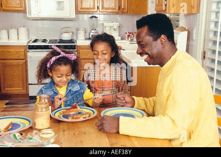 Papa et ses deux filles en cuisine faire déjeuner amusant multi culturel multiculturel la diversité raciale diversité ethnique ethnique ©M. Pearson Myrleen Banque D'Images