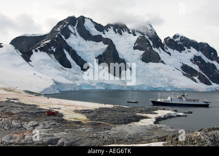 Les touristes extraire une Gentoo pingouin Pygoscelis papua colonie le long de la péninsule Antarctique de l'ouest Banque D'Images