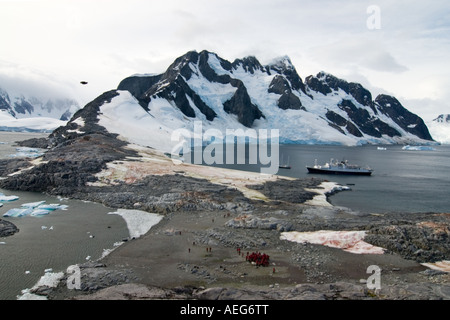 Les touristes extraire une Gentoo pingouin Pygoscelis papua colonie le long de la péninsule Antarctique de l'ouest Banque D'Images