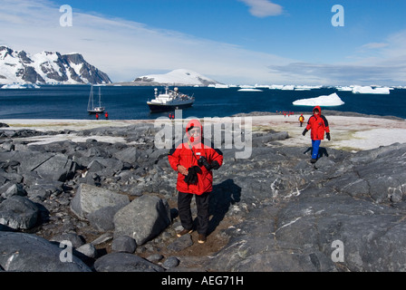 Les touristes extraire une Gentoo pingouin Pygoscelis papua colonie le long de la péninsule Antarctique de l'ouest Banque D'Images